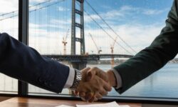 Close-up of a handshake between professionals with a construction view.