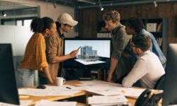 A team collaborates in a modern office over a digital 3D building model.